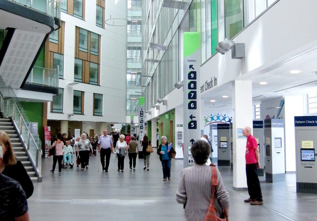 Southmead hospital main reception atrium with visitors and patients.