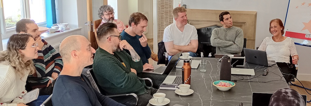 Calvium team sat around a conference table, smiling, interested, taking notes.