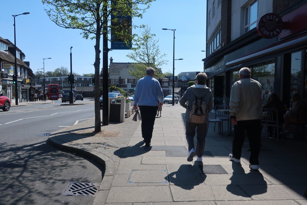 Three mature people walking down a street
