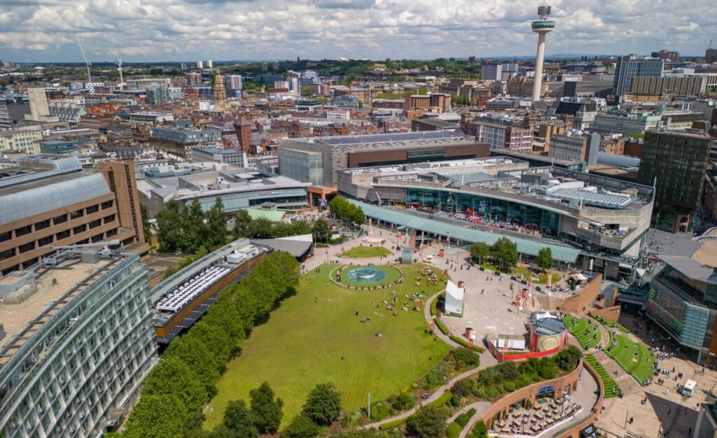 Aerial view over park and Liverpool One buildings, with Liverpool extending to the horizon behind.