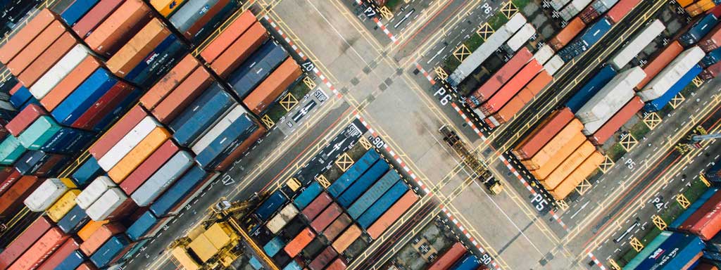 Aerial view of piles of shipping containers at a port.