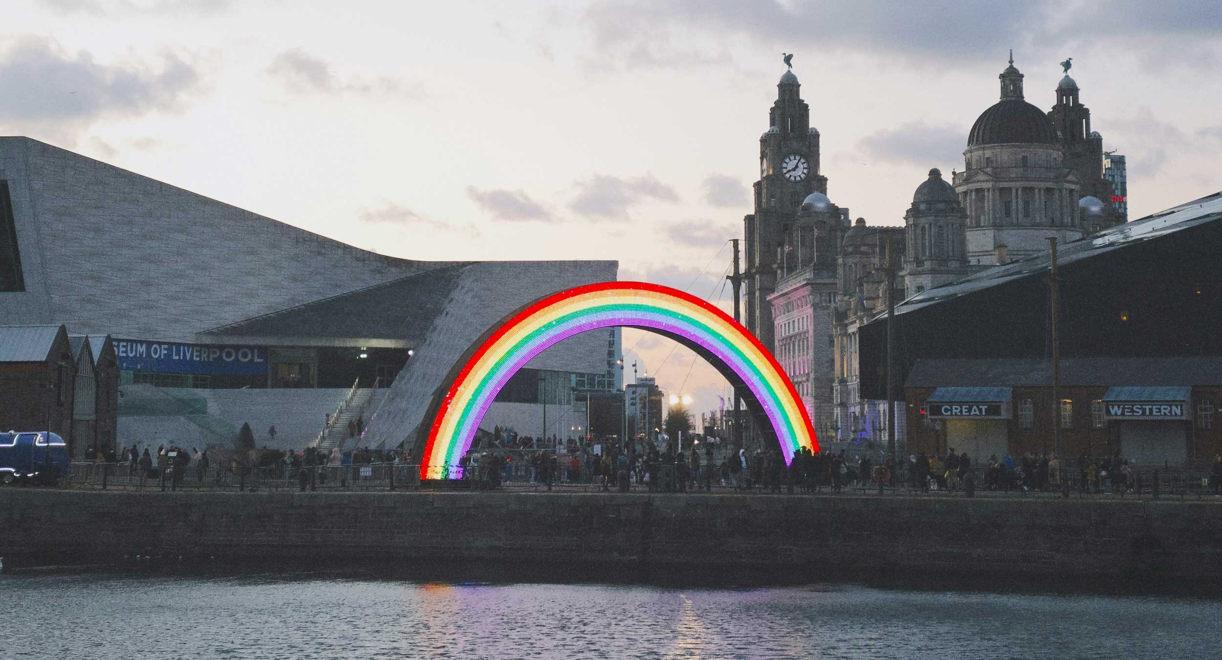 Glowing rainbow sculpture as the sun sets, outside Museum of Liverpool.