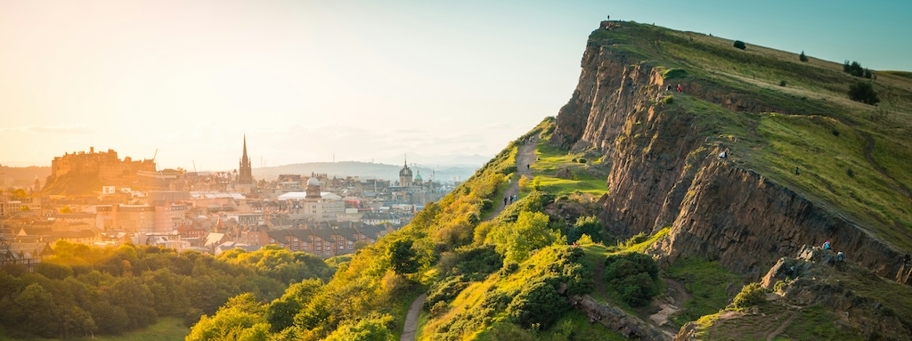 View past Arthur's Mount hill, over to Edinburgh, at sunset.