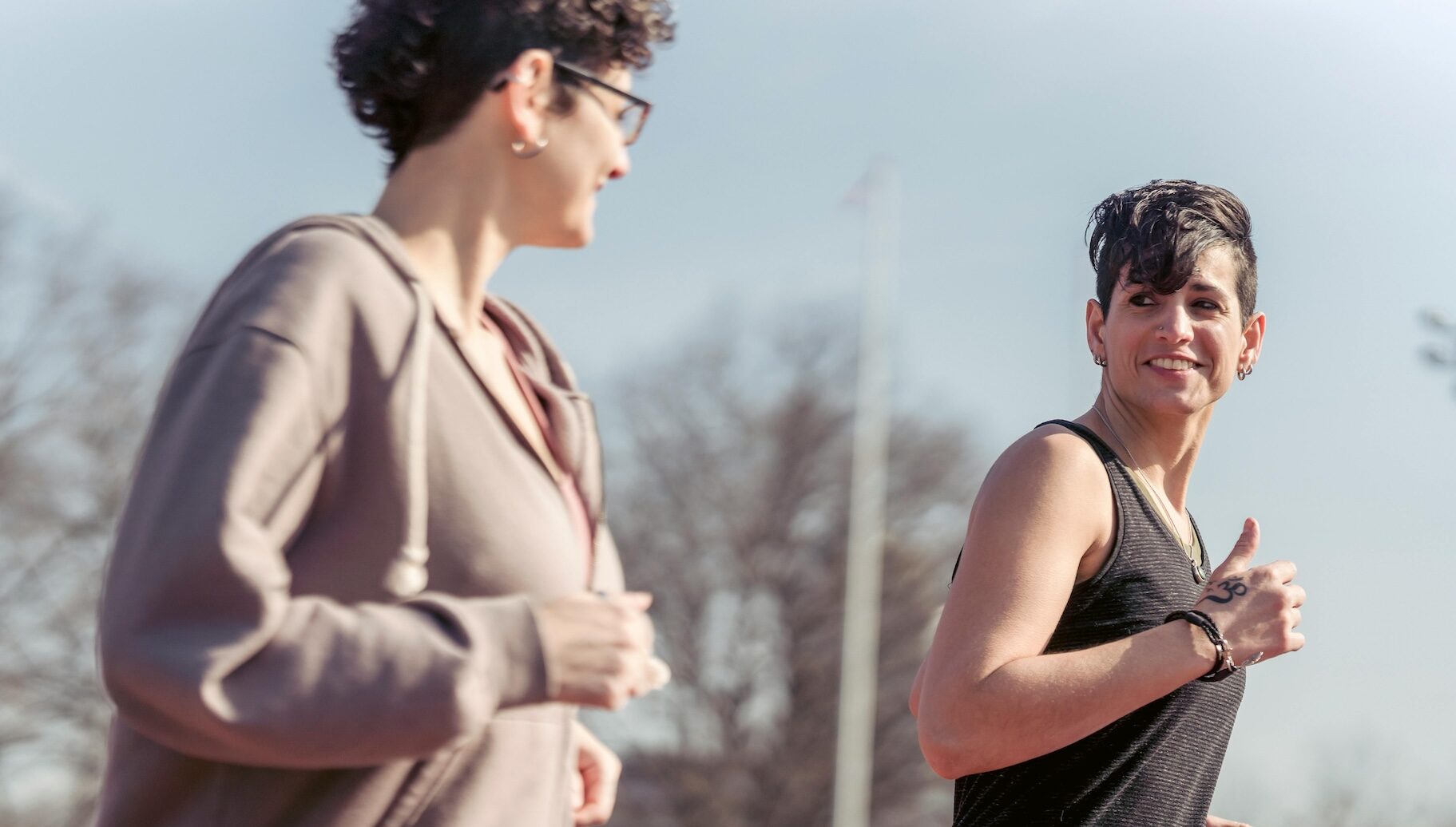 Two women smiling and jogging outside